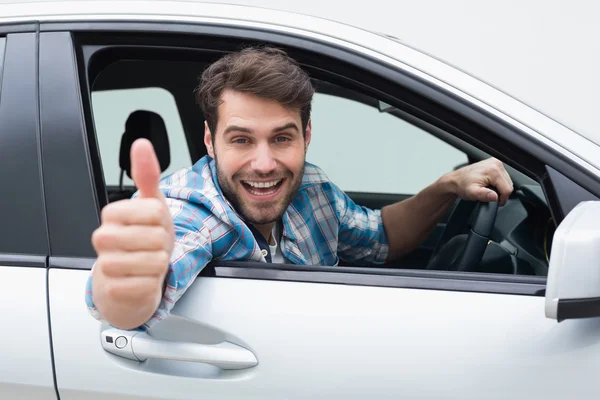 Joven sonriendo y mostrando los pulgares hacia arriba — Foto de Stock