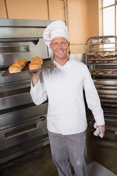 Baker segurando bandeja de pão fresco — Fotografia de Stock