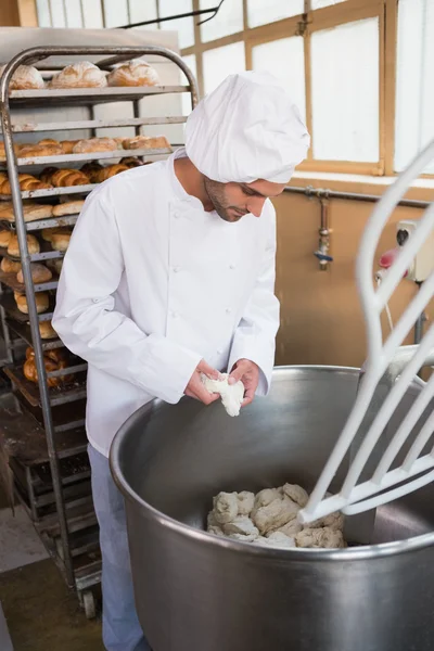Baker preparing dough in industrial mixer — Stock Photo, Image