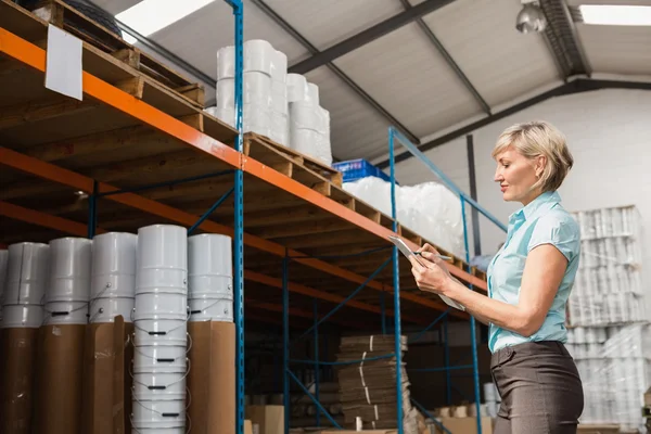 Warehouse manager checking her list — Stock Photo, Image