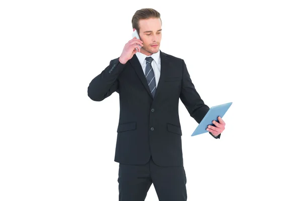 Serious businessman on the phone holding tablet — Stock Photo, Image