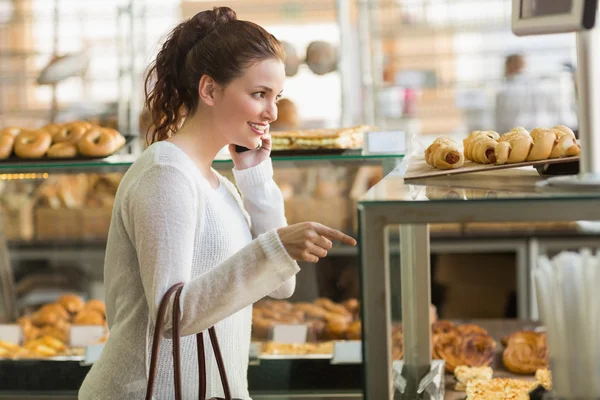 Bella bruna che sceglie una pasticceria — Foto Stock