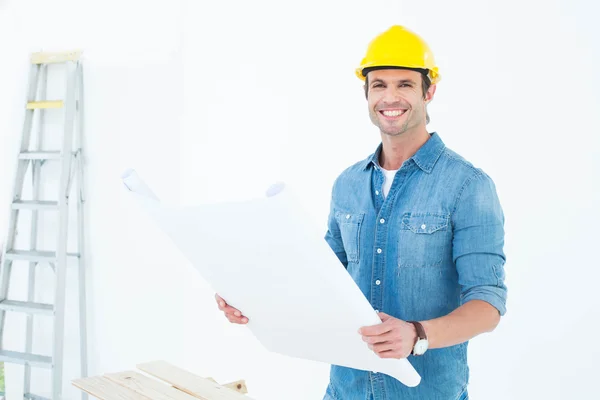 Happy architect holding blueprint in house — Stock Photo, Image