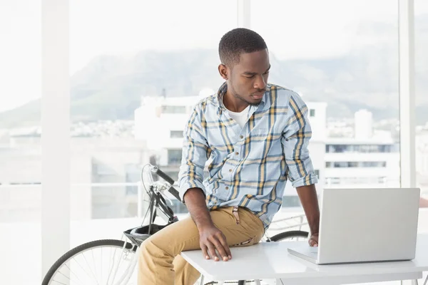 Seriöser Geschäftsmann sitzt und nutzt Laptop — Stockfoto
