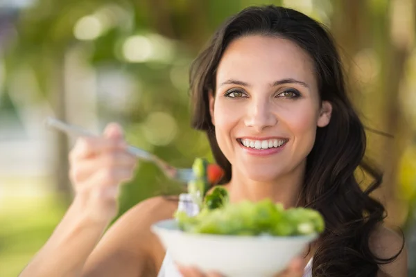 Pretty brunette eating bowl of salad — Stock Photo, Image