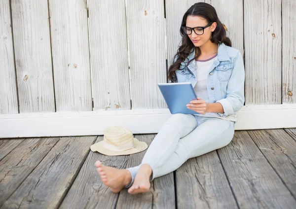 Hipster assis sur le sol avec une tablette — Photo