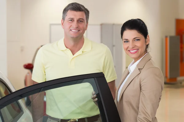 Mujer de negocios mostrando el interior del coche al cliente —  Fotos de Stock