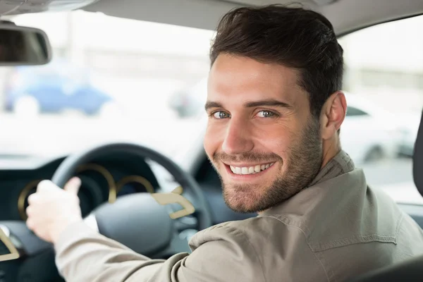 Jovem sorrindo enquanto dirige — Fotografia de Stock