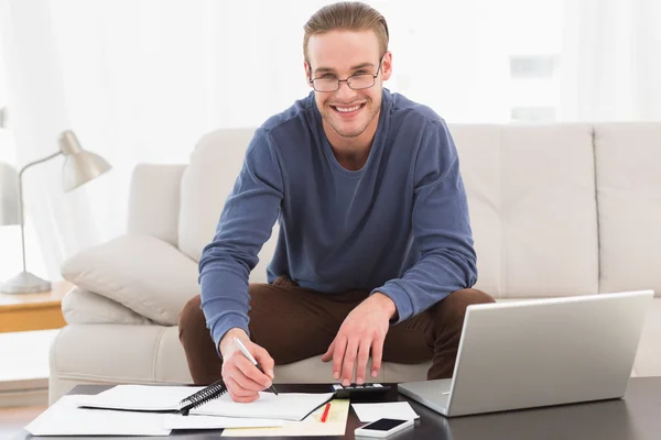 Smiling man using calculator counting his bills — Stock Photo, Image