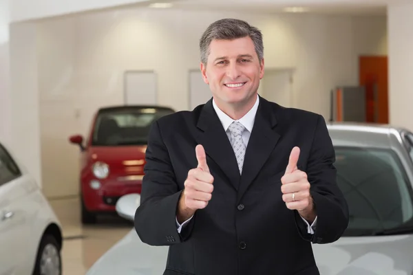 Businessman standing while giving thumbs up — Stock Photo, Image