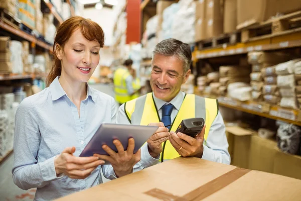 Warehouse managers looking at tablet pc — Stock Photo, Image