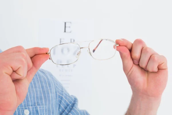 Mãos segurando óculos para teste ocular — Fotografia de Stock