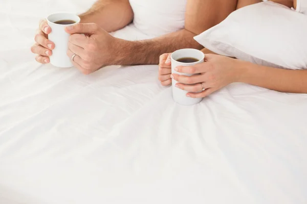 Молодая пара пьет кофе в постели — стоковое фото