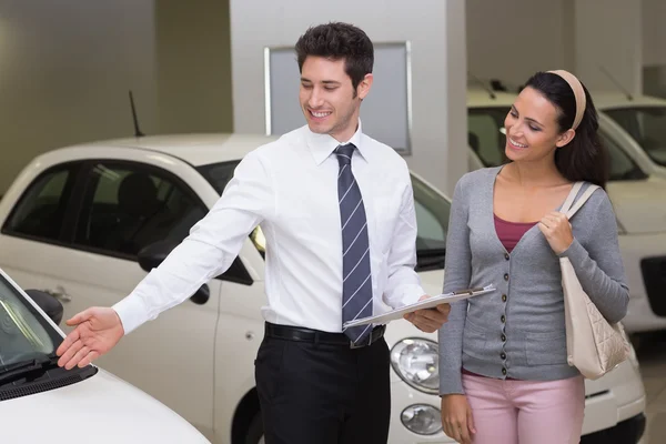 Businessman showing car to woman — Stock Photo, Image