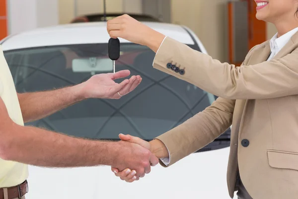 Kobieta daje klucz drżenie ręki klienta — Zdjęcie stockowe