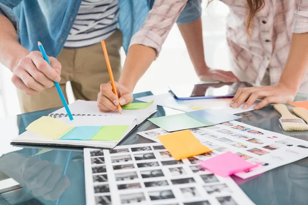 Kollegen schreiben Notizen und bearbeiten Fotos — Stockfoto