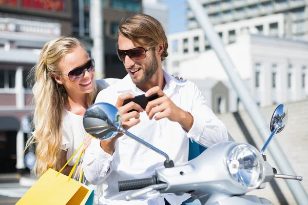 Attractive couple riding a scooter — Stock Photo, Image