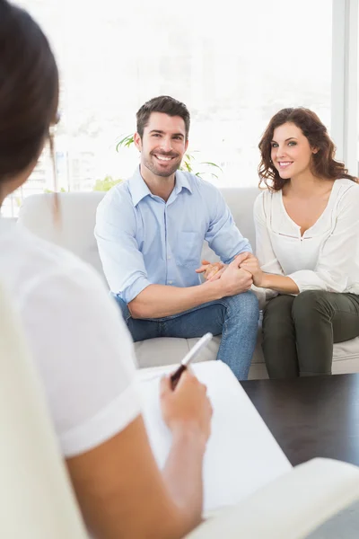 Reconciled couple smiling on couch — Stock Photo, Image