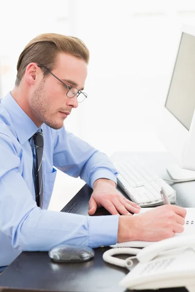 Geschäftsmann mit Brille macht sich Notizen — Stockfoto