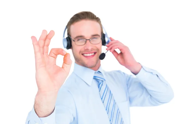 Hombre de negocios sonriente con auriculares haciendo señal de ok —  Fotos de Stock