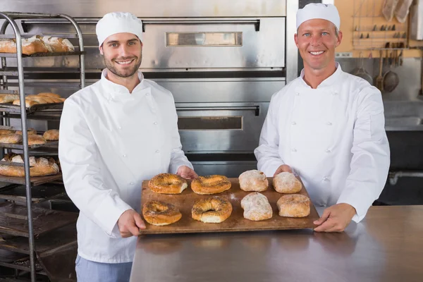 Cozinheiros sorrindo com bandejas de pão — Fotografia de Stock