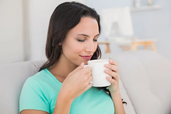 Žena, pití kávy na gauči — Stock fotografie