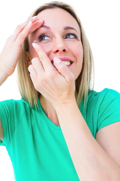 Smiling blonde applying contact lens — Stock Photo, Image