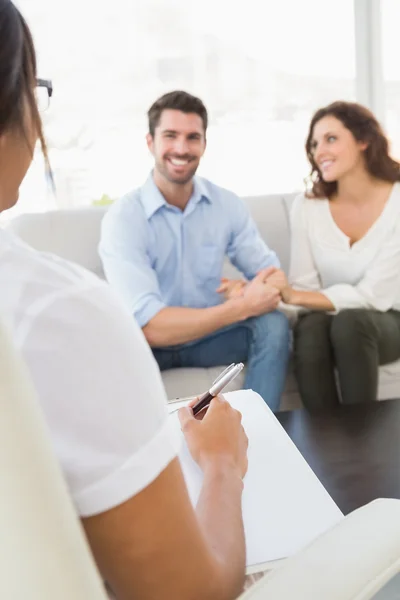 Smiling couple speaking with therapist — Stock Photo, Image