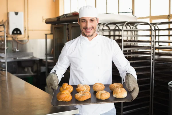 Panettiere che mostra vassoio di rotoli — Foto Stock