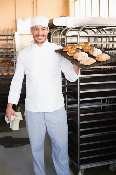Baker holding tray of bread — Stock Photo, Image