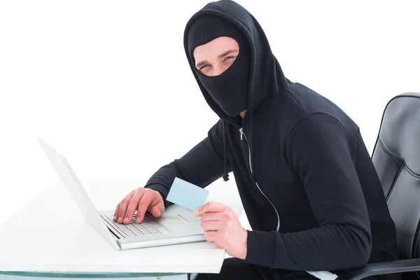 Hacker using laptop and credit card — Stock Photo, Image