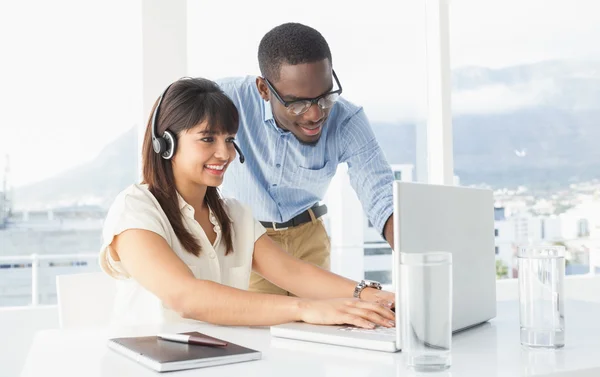 Coworkers using laptop and headset — Stock Photo, Image