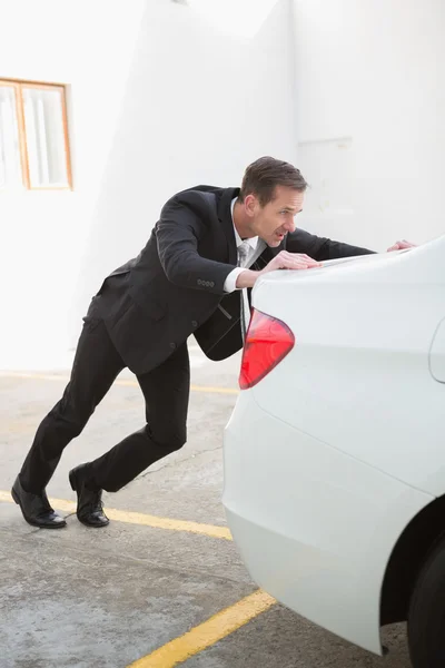 Businessman pushing his broken down car — Stock Photo, Image