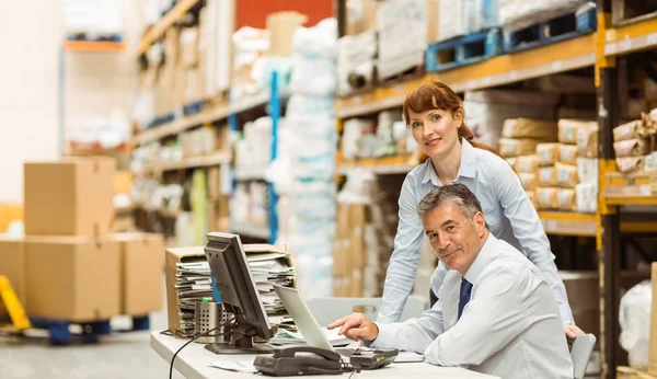 Warehouse managers working together on laptop — Stock Photo, Image