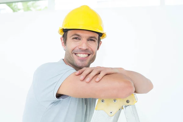 Happy technician leaning on step ladder — Stock Photo, Image