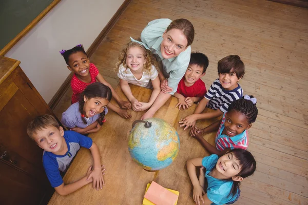 Schattig leerlingen glimlachend rond een globe — Stockfoto