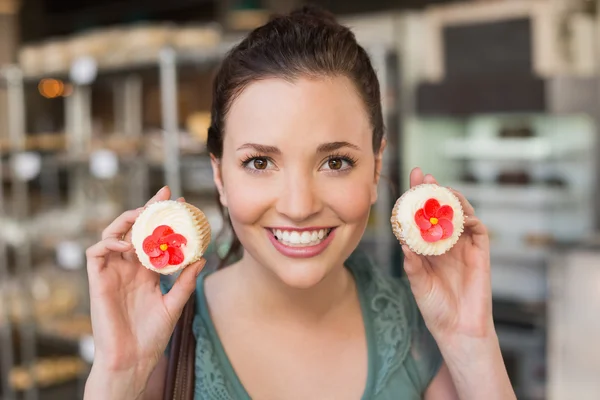 Mooie brunette tonen een cupcake — Stockfoto