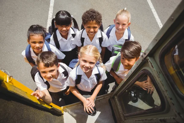 Cute schoolchildren getting on school bus — Stock Photo, Image