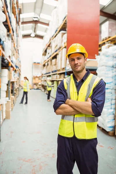 Magazijnmedewerker glimlachen op camera met gekruiste armen — Stockfoto