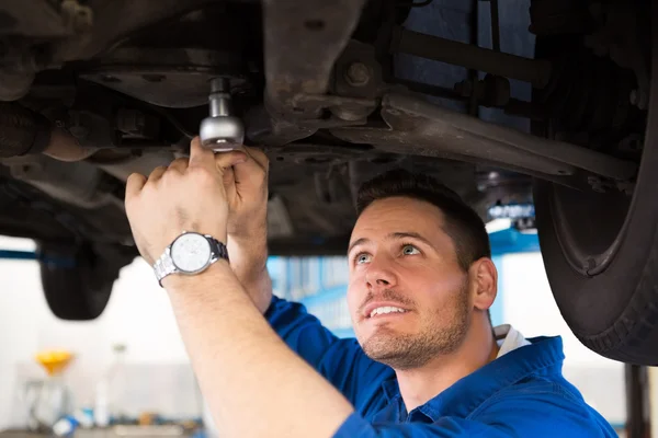 Mechaniker untersucht unter dem Auto — Stockfoto