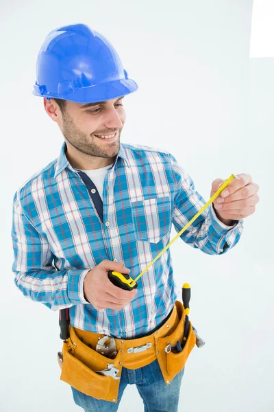Feliz carpintero mirando cinta métrica — Foto de Stock