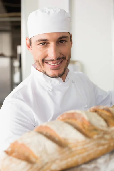 Szczęśliwy piekarz biorąc pod uwagę świeży chleb — Zdjęcie stockowe
