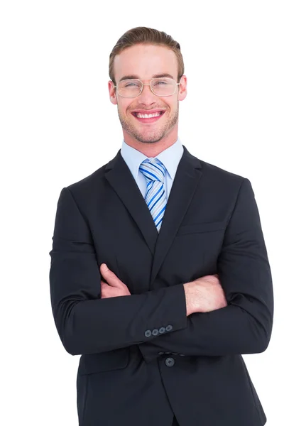 Улыбающийся бизнесмен в костюме со скрещенными руками — стоковое фото