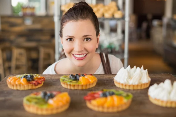 Morena bonita olhando para tortas — Fotografia de Stock