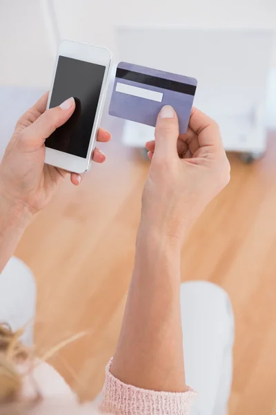Žena drží telefon a kreditní karty — Stock fotografie