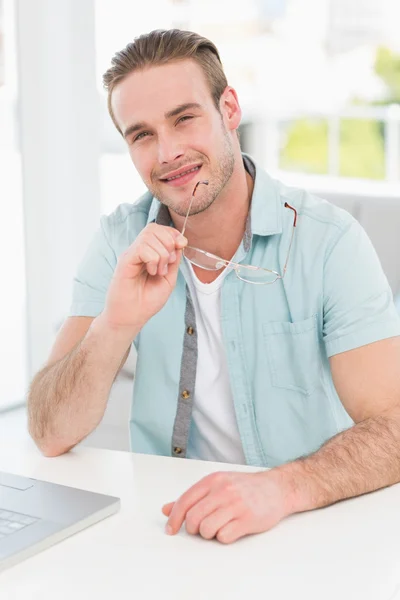 Uomo d'affari sorridente che tiene gli occhiali — Foto Stock