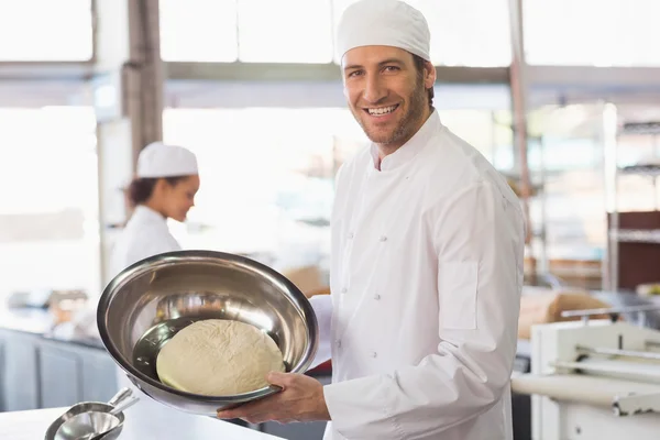 Baker showing dough in mixing bowl — Stock Photo, Image