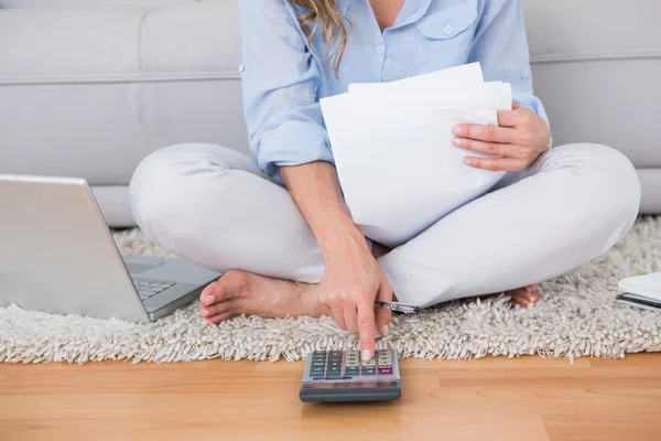 Rubia en la alfombra usando calculadora — Foto de Stock