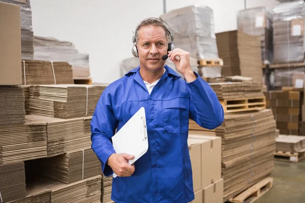 Trabajador de almacén serio usando auriculares —  Fotos de Stock