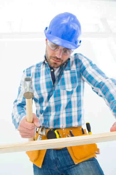 Timmerman raken spijker op houten plank — Stockfoto